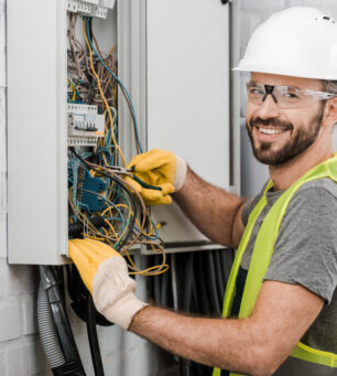 Smiling,Handsome,Electrician,Repairing,Electrical,Box,With,Pliers,In,Corridor Smiling,Handsome,Electrician,Repairing,Electrical,Box,With,Pliers,In,Corridor